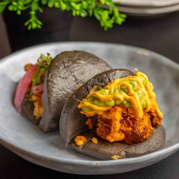 Bao negro de pollo crujiente con almogrote y guacamole en The Rumors Gastrobar
