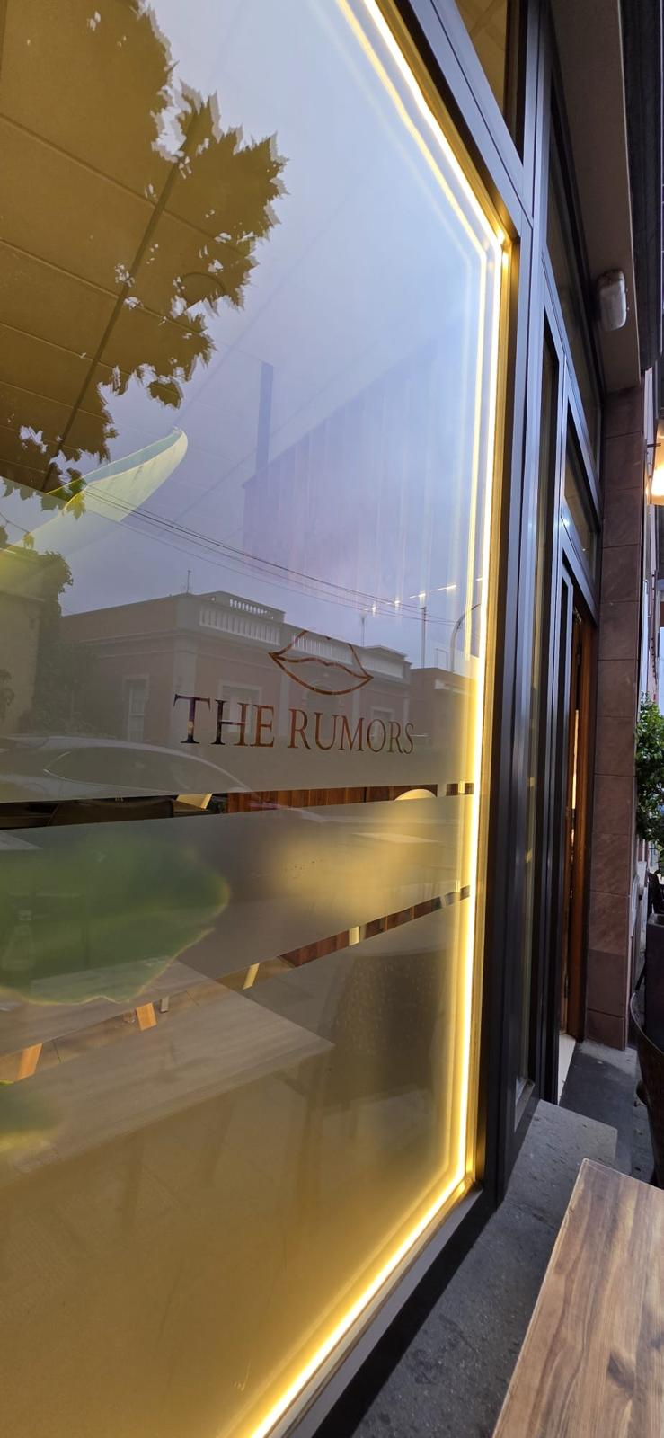 Escaparate iluminado con el logo de The Rumors Gastrobar en Tegueste
