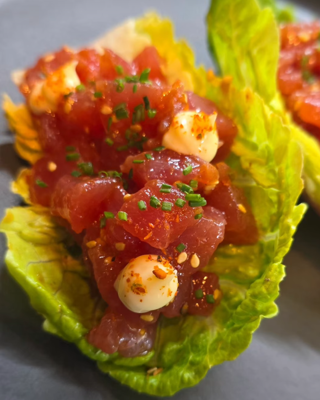 Tartar de atún con toques picantes servido sobre lechuga en The Rumors Gastrobar